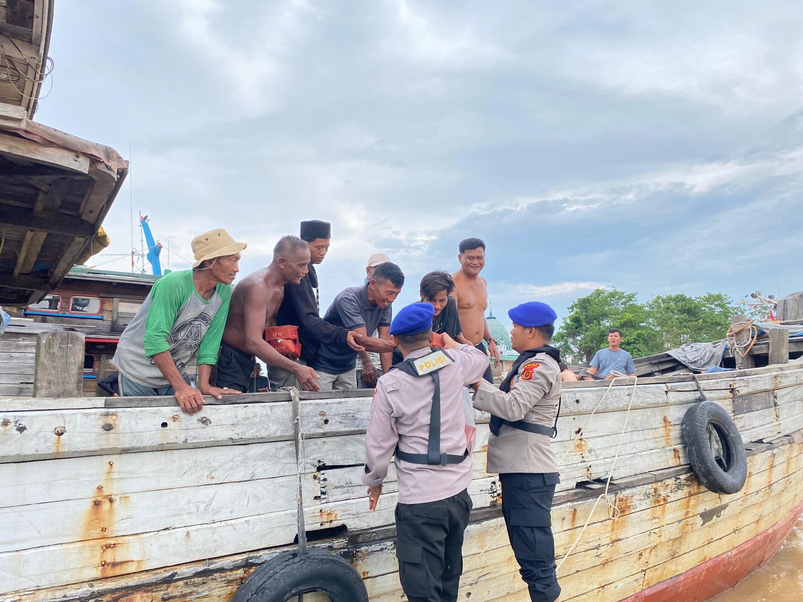 Personel Ditpolairud Polda Jambi saat membagikan takjil kepada nelayan